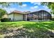 A well-manicured lawn with a covered pool and patio area, creating a serene and private backyard oasis at 32613 View Haven Ln, Sorrento, FL 32776