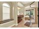 Bright bathroom featuring a garden tub with an arched window and a separate glass shower at 32613 View Haven Ln, Sorrento, FL 32776