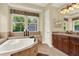 Luxurious bathroom showcasing a modern soaking tub, granite countertops, and decorative accents at 32613 View Haven Ln, Sorrento, FL 32776