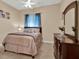 Neutral toned bedroom featuring a large dresser and a window with patterned curtains at 32613 View Haven Ln, Sorrento, FL 32776