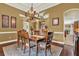 Dining room with decorative chandelier, hardwood floors, large window, and views of the front yard at 32613 View Haven Ln, Sorrento, FL 32776