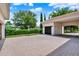Attached two-car garage with an extended brick driveway and lush landscaping enhancing the curb appeal at 32613 View Haven Ln, Sorrento, FL 32776