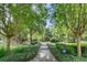 Lush community garden featuring a peaceful path with manicured hedges and mature trees providing shade at 32613 View Haven Ln, Sorrento, FL 32776