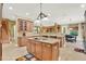 Large kitchen featuring a center island with a cooktop and bar seating, custom cabinets and stainless steel appliances at 32613 View Haven Ln, Sorrento, FL 32776