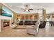 Inviting living room features a cozy fireplace, mounted TV, large sectional seating, and a ceiling fan at 32613 View Haven Ln, Sorrento, FL 32776