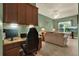 A home office featuring a built-in desk, cozy seating, and a tranquil view from the window at 32613 View Haven Ln, Sorrento, FL 32776