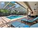 Relaxing poolside with lounge chairs and a clear view of the screened-in pool and spa at 32613 View Haven Ln, Sorrento, FL 32776