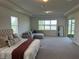 Expansive bedroom with water view, a cozy seating area, and lots of natural light at 3399 Buoy Cir, Winter Garden, FL 34787