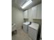 Bright laundry room featuring white washer, dryer, cabinets, and utility sink at 3399 Buoy Cir, Winter Garden, FL 34787