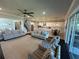 Bright and open living room with ceiling fan, plush sofas, and seamless access to dining and kitchen at 3399 Buoy Cir, Winter Garden, FL 34787