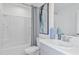Bright bathroom featuring a shower-tub combo with tiled walls, modern fixtures, and decorative art at 3527 Mayfair St, Kissimmee, FL 34758
