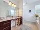 Well-lit bathroom featuring an extended vanity and a view to the tub and window at 4729 Spindletree Ln, Orlando, FL 32829