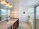 Well-lit bathroom featuring a vanity and a view to the tub with a shower at 4729 Spindletree Ln, Orlando, FL 32829