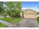 Charming one-story home with a two-car garage and a well-manicured lawn featuring lush landscaping at 4729 Spindletree Ln, Orlando, FL 32829