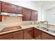 Modern kitchen features stainless steel appliances, dark wood cabinets and a smooth surface cooktop at 4729 Spindletree Ln, Orlando, FL 32829