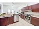 Open kitchen with stainless steel appliances and dark wood cabinets leads to a cozy living area at 4729 Spindletree Ln, Orlando, FL 32829