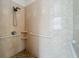 Accessible tiled shower is equipped with grab bars, and a handheld shower head at 4729 Spindletree Ln, Orlando, FL 32829