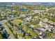 An aerial view shows this property surrounded by lush trees and foliage in a neighborhood near a body of water at 4916 Winwood Way, Orlando, FL 32819