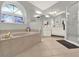 Bright bathroom featuring a large tub, double vanity, and decorative arched window at 4916 Winwood Way, Orlando, FL 32819