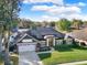 This single-story home boasts a lush front lawn, attached garage, and solar panels on the roof at 4916 Winwood Way, Orlando, FL 32819