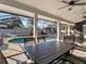 Covered patio with an outdoor dining table and a view of the sparkling pool at 4916 Winwood Way, Orlando, FL 32819