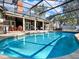This beautiful screened-in pool area features mature trees, outdoor seating, and ample space for relaxing at 4916 Winwood Way, Orlando, FL 32819