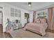 Well-lit bedroom featuring pink bedding, a closet, hard wood floors, and ample natural light at 5205 Saint Regis Pl, Belle Isle, FL 32812
