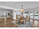 Bright dining area with wood floors, stylish light fixture, and seamless access to the kitchen and pool at 5205 Saint Regis Pl, Belle Isle, FL 32812