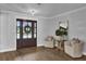 Welcoming foyer features wood floors, stylish seating, neutral decor and a lovely entry door at 5205 Saint Regis Pl, Belle Isle, FL 32812