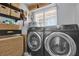Well-organized laundry room with black front-load machines and plenty of storage baskets at 5205 Saint Regis Pl, Belle Isle, FL 32812