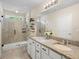 Elegant bathroom with granite countertops, dual sinks, a tiled shower, and a large mirror at 5298 Royal Point Ave, Kissimmee, FL 34746