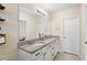 Bathroom featuring double vanity with granite counters and large mirror at 5298 Royal Point Ave, Kissimmee, FL 34746