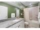 Bathroom featuring green walls, a granite-topped vanity, and a shower-tub combo at 5298 Royal Point Ave, Kissimmee, FL 34746