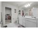 Bright bathroom with double sinks, white cabinets, and a door leading to walk-in closet at 5329 Royal Point Ave, Kissimmee, FL 34746