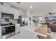 Open kitchen with stainless appliances, island seating, white cabinets, and a view into the living area at 5329 Royal Point Ave, Kissimmee, FL 34746