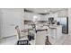 Eat-in kitchen with an island, stainless steel appliances, white cabinets, and a glass top table at 5329 Royal Point Ave, Kissimmee, FL 34746