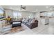 Open-concept living room featuring tile floors, a ceiling fan, and a large sectional couch for comfort at 5329 Royal Point Ave, Kissimmee, FL 34746