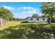 Expansive backyard with lush green grass, mature trees, and a view of the home's rear facade at 5402 Kingswood Dr, Orlando, FL 32810