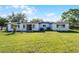 Spacious backyard featuring a well-maintained lawn, mature trees, and a simple patio area at 5402 Kingswood Dr, Orlando, FL 32810