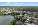 Lush aerial view capturing a community bordering a tranquil lake, surrounded by greenery and beautiful homes at 549 Mcneal Dr, Deltona, FL 32725