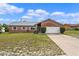 Charming brick home featuring a well-maintained lawn and attached two-car garage at 549 Mcneal Dr, Deltona, FL 32725