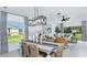 Bright dining area with stylish lighting fixture and views into the adjacent living room at 5663 Loggia Ln, Kissimmee, FL 34758