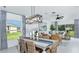 Bright dining area with stylish lighting fixture and views into the adjacent living room at 5663 Loggia Ln, Kissimmee, FL 34758