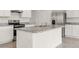Bright kitchen featuring white cabinets, stainless steel appliances, and an island with a sink and gray countertop at 715 Chinoy Rd, Davenport, FL 33837