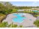 Overhead view of community pool with splash pad and lounge chairs, surrounded by palm trees at 715 Chinoy Rd, Davenport, FL 33837