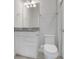 Well-lit bathroom features a granite countertop, white cabinets, and modern fixtures at 7772 Sweet Star Avenue, Orlando, FL 32836