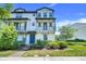 Charming townhouse featuring dual balconies, a stylish blue front door, and professionally landscaped front yard at 7772 Sweet Star Avenue, Orlando, FL 32836