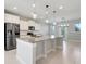 Open kitchen featuring an island, granite countertops, and stainless steel appliances at 7772 Sweet Star Avenue, Orlando, FL 32836
