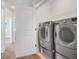Modern laundry room with stainless steel washer and dryer and view to hallway at 7772 Sweet Star Avenue, Orlando, FL 32836