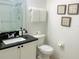 Bathroom featuring a granite-topped vanity, a toilet, decorative artwork, and a glass-enclosed shower at 8023 King Palm Cir, Kissimmee, FL 34747